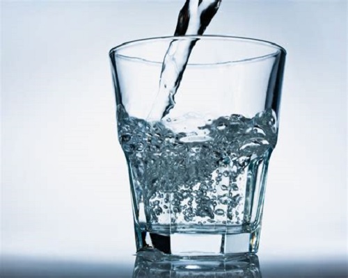 Glas wird mit Wasser befüllt 