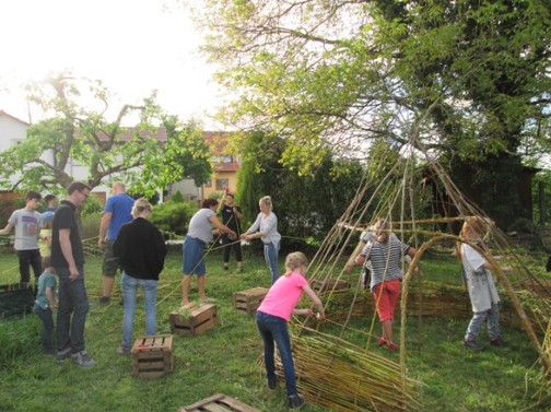 Kinder bauen aus Weide ein Tippi.