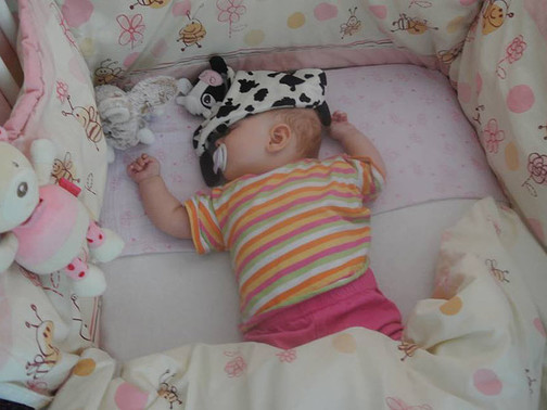 Ein Baby schläft im Babybett.